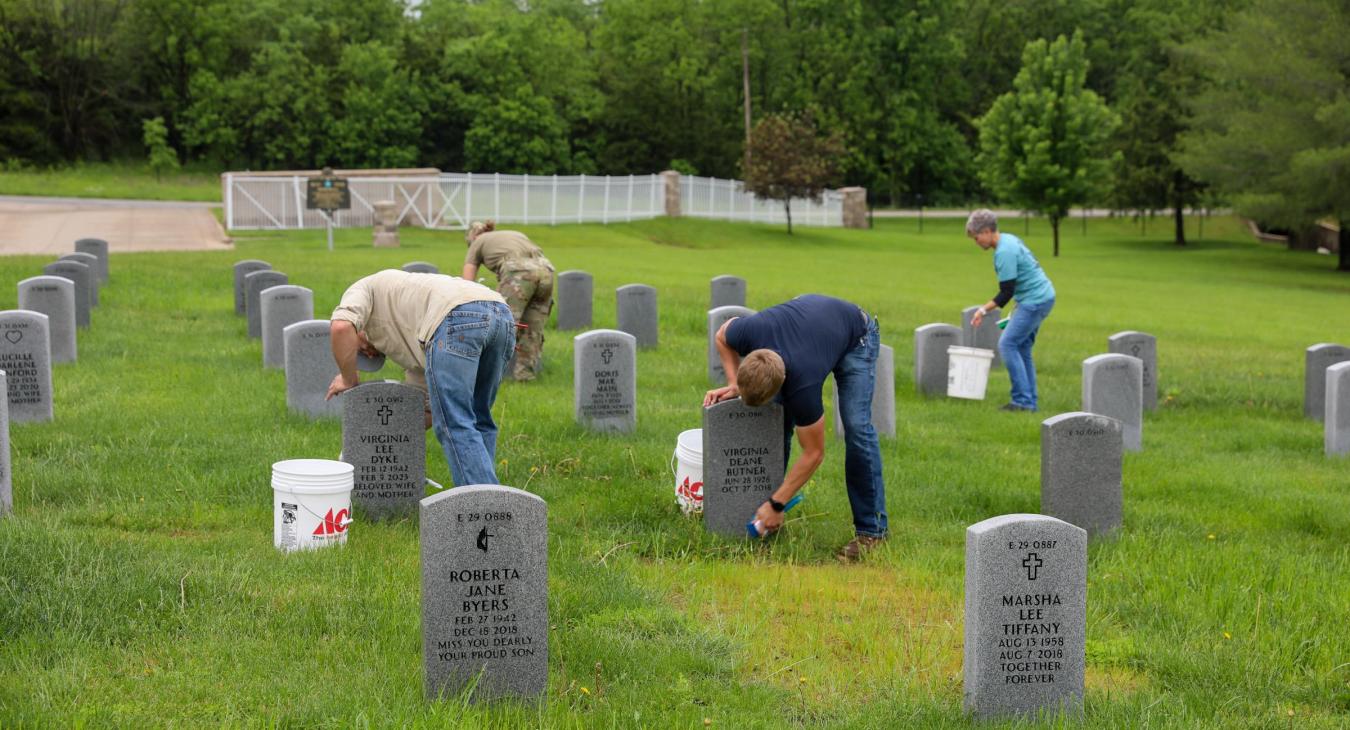 Linemen cleaning headstones