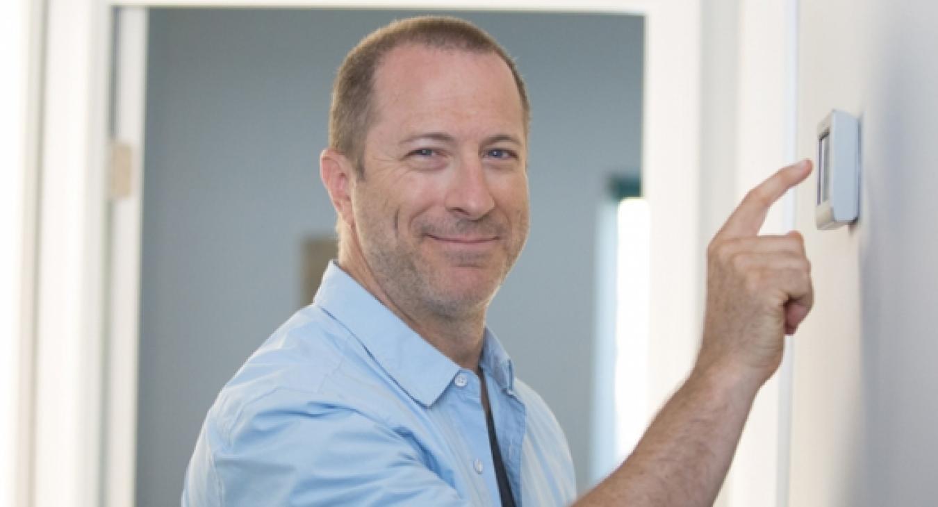 A man adjusting a thermostat